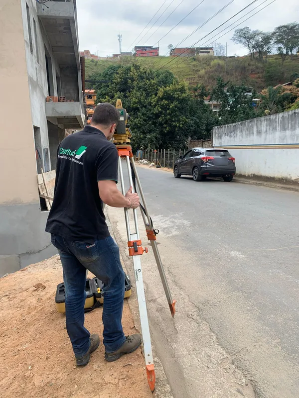 Aloísio Sartori com a estação total montada no tripé, à beira de uma rua